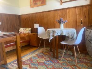 a table with two chairs and a vase of flowers on it at Espacio Rural Los Castaños in Cercedilla