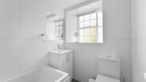 a white bathroom with a toilet and a sink at Pavement Cottage in Ambleside +15 photos