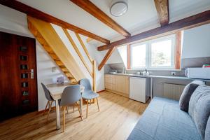 a kitchen and dining room with a table and a couch at Stara Piekarnia - Jagiellońska in Olsztyn