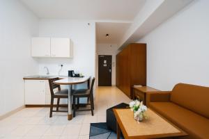a living room and kitchen with a couch and a table at 103 Hotel by manatidur in Kuala Lumpur