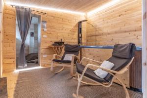 two chairs in a room with wooden walls at Chalet & SPA Privata - Baita al Frassino, Ospitar in Vignola