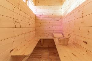 a wooden sauna with a bench and a bucket at Chalet & SPA Privata - Baita al Frassino, Ospitar in Vignola