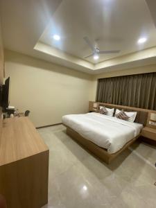 a bedroom with a bed and a television in it at hotel arya inn in Prayagraj