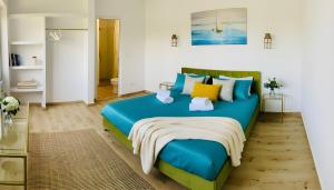 a bedroom with a blue bed with colorful pillows at Casa de Oaspeti 2 Mai in 2 Mai