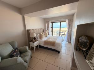 a bedroom with a bed and a couch and a balcony at Klein paradys Jeffreys bay in Jeffreys Bay +20 photos
