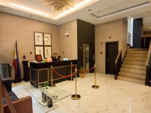a lobby with a piano and stairs with a flag at Windy Ridge Hotel Malate Manila in Manila