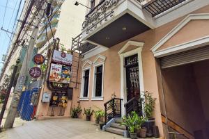 a building on a street with plants in front of it at Windy Ridge Hotel Malate Manila in Manila