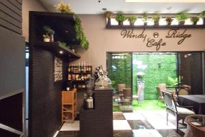 a restaurant with a bar and a dining room at Windy Ridge Hotel Malate Manila in Manila