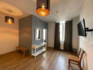 a living room with a table and a mirror and a television at Le Cecil in Liège