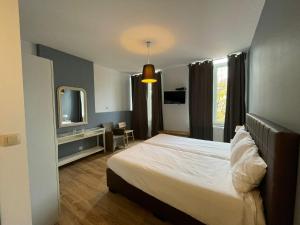 a bedroom with a large bed and a television at Le Cecil in Liège