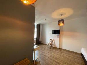 a room with a bed and a table and a chair at Le Cecil in Liège +39 photos