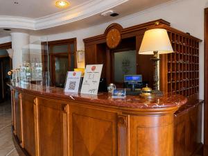 a large wooden bar in a room with a lamp at Hotel Valle Rossa in San Giovanni Rotondo