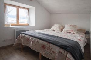 a bedroom with a bed with a blanket and a window at RealView - Chalet 3 Chambres in Réal