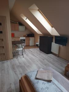 a room with a bed and a table and a kitchen at Apartamenty Sokółka II in Sokółka