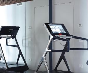 a treadmill and a laptop on a stand in a room at Villa Acquariva Private Heated Pool in Salò