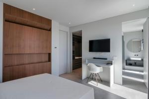 a bedroom with a bed and a desk and a television at Villa Acquariva Private Heated Pool in Salò +35 photos