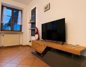 a flat screen tv sitting on top of a wooden table at ElvesHome - Alpine Stay Apartments in Predazzo