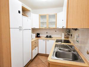 a small kitchen with a sink and white appliances at ElvesHome - Alpine Stay Apartments in Predazzo