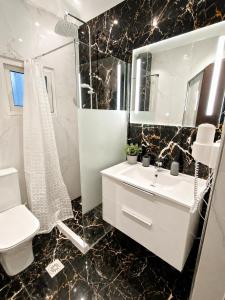 a black and white bathroom with a sink and a mirror at Flogita 5 Seaside Apartments - 150m from Beach, Ideal for Families & Groups in Flogita
