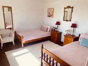 a bedroom with two beds and a mirror and a chair at Seaview in Duneen