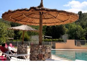a umbrella and chairs next to a swimming pool at Aloha Camping Club in Reynès