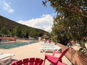 a group of chairs sitting next to a swimming pool at Aloha Camping Club in Reynès
