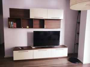 a living room with a flat screen tv on a entertainment center at Panoramic Sea View Apartment Saranda in Sarandë
