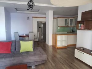 a living room with a couch and a kitchen at Panoramic Sea View Apartment Saranda in Sarandë