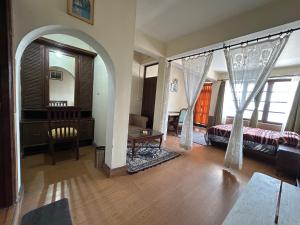 a bedroom with a bed and a living room with a table at Lloyd's Vintage Home in Bhowāli
