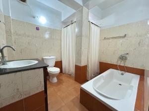 a bathroom with a sink and a tub and a toilet at Lloyd's Vintage Home in Bhowāli +69 photos