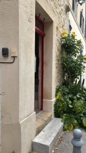 an entrance to a building with a red door at Petit cocon à 10min d'Avignon in Pujaut