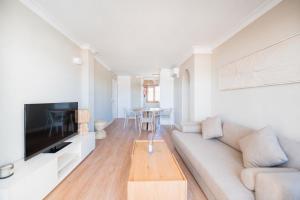 a white living room with a couch and a table at CARABELA 94 in Alcudia