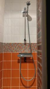 a shower in a bathroom with orange and white tiles at Petit cocon à 10min d'Avignon in Pujaut
