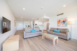 a living room with two couches and a table at Akama Resort in Hervey Bay