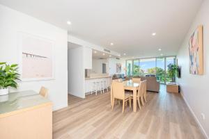 a kitchen and dining room with a table and chairs at Akama Resort in Hervey Bay +12 photos