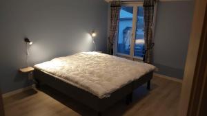 a large bed in a room with a window at Marieborg Apartments in Ekshärad +19 photos