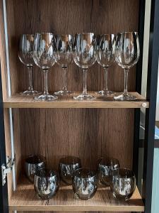 a row of wine glasses on a wooden shelf at Gonta house in Skhidnitsa