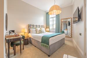 a hotel room with a bed and a desk and a bedroom at Crescent Inn by Maison Pierre in Ilkley
