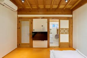 a room with a bed and a kitchen at Hanok Moonstay in Gyeongju