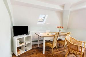a dining room with a table and a tv at Ferienwohnung im ehem Rittergut in Wurzbach