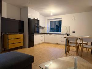 a living room with a kitchen and a dining room at MAAN Apartments in Augustów +12 photos