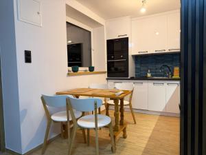 a kitchen with a wooden table and chairs at MAAN Apartments in Augustów