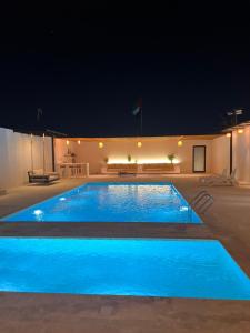 a large blue swimming pool at night at Mykonos Resort in Abu Dhabi