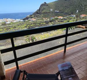 a chair sitting on a balcony looking out at the ocean at FINCA LA JORADITA in Tamaduste