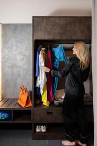 a woman is reaching into a closet at Hotel Moderno in Bari