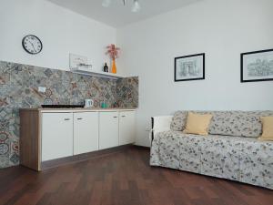 a living room with a couch and a clock on the wall at Villa del Mar Country Loft in Sassari