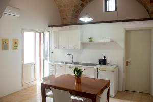 a kitchen with a table and chairs and a sink at Felline centro storico in Felline