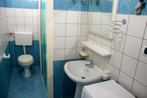 a blue and white bathroom with a toilet and a sink at Felline centro storico in Felline