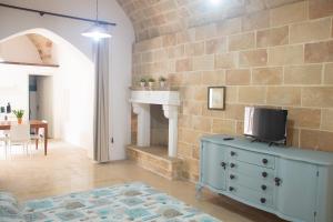 a living room with a blue dresser with a tv on it at Felline centro storico in Felline +10 photos