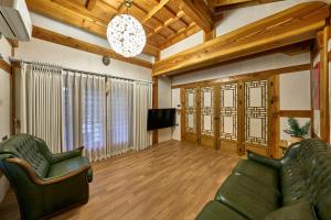 a living room with a couch and a tv at Hanok Moonstay in Gyeongju